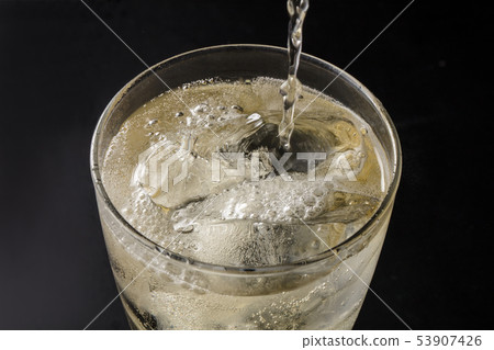 傾吐的highball入在黑背景的玻璃 53907426