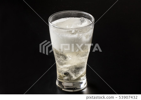 Pouring highball into glass on black background Pouring highball into glass on black background 53907432