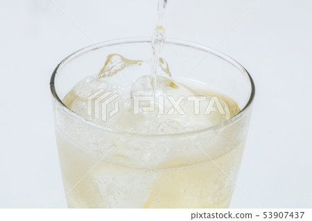 Pouring highball into glass on white background Pouring highball into glass on white background 53907437