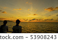 silhouettes of two women watching sunset 53908243
