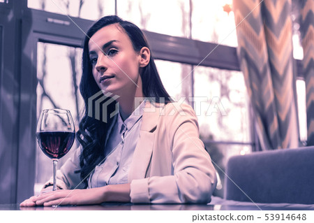 Nice young woman sitting in front of the wine glass Nice young woman sitting in front of the wine glass 53914648