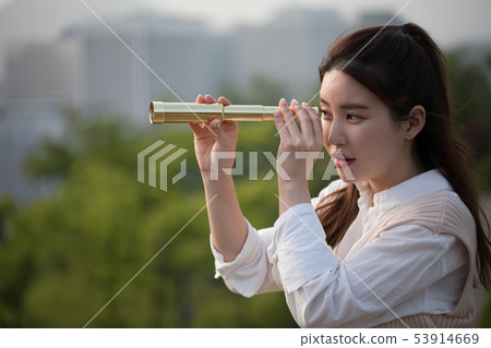 A woman watching a telescope 53914669
