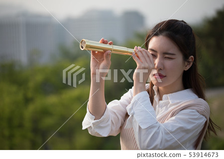 A woman watching a telescope A woman watching a telescope 53914673