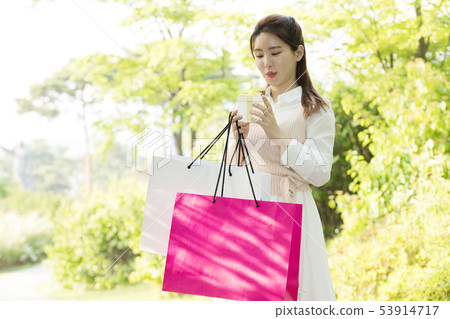 一個女人帶著購物袋 53914717