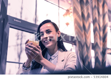 Delighted happy woman giving holding a glass of juice 53914804