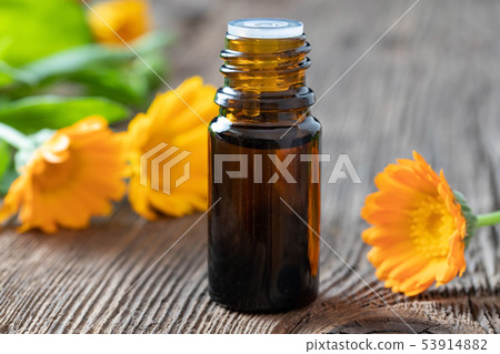 A bottle of calendula essential oil with calendula A bottle of calendula essential oil with calendula 53914882