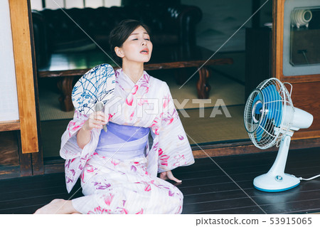 A woman in a yukata using a fan and fan 53915065