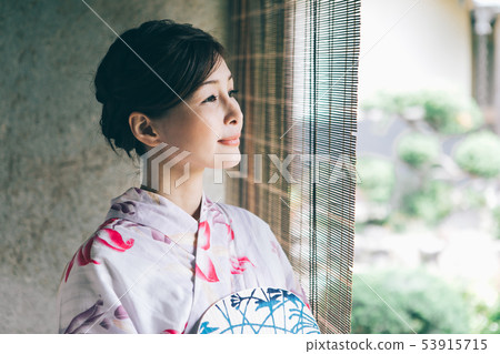 A woman in a yukata that cools on the veranda A woman in a yukata that cools on the veranda 53915715