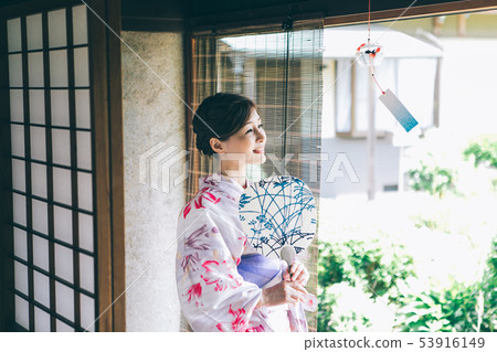 A woman in a yukata that cools on the veranda 53916149