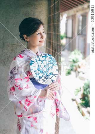 A woman in a yukata that cools on the veranda A woman in a yukata that cools on the veranda 53916912