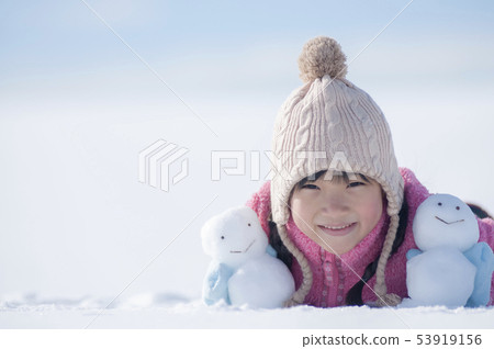 有一個雪人的微笑的女孩在一個多雪的領域 53919156