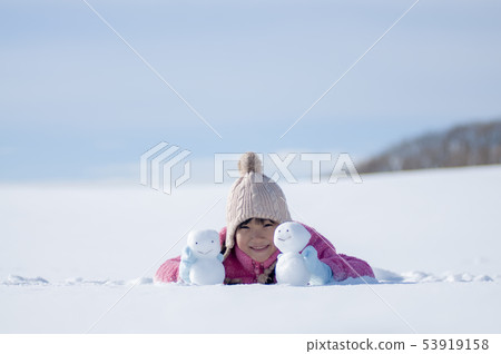 有一個雪人的微笑的女孩在一個多雪的領域 53919158