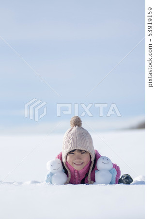 有一個雪人的微笑的女孩在一個多雪的領域 53919159