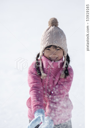Smiling girl playing in the snow 53919165
