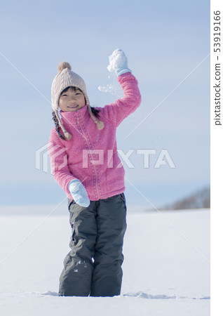 Smiling girl playing in the snow Smiling girl playing in the snow 53919166