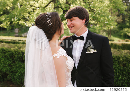 Happy groom and bride walking in the park. Charming woman with handsome man spend time together Happy groom and bride walking in the park. Charming woman with handsome man spend time together 53920253