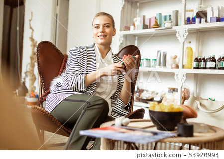 Calm beautiful woman resting in waiting zone of beauty studio Calm beautiful woman resting in waiting zone of beauty studio 53920993