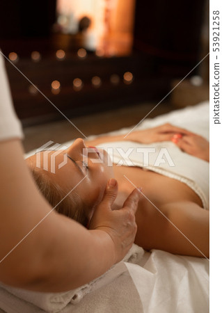 Attractive blonde lady peacefully lying on a matrass covered in white blanket Attractive blonde lady peacefully lying on a matrass covered in white blanket 53921258