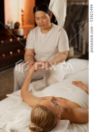 Blonde good-looking woman with closed eyes lying on covered bed Blonde good-looking woman with closed eyes lying on covered bed 53921494
