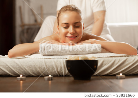 Cheerful appealing lady putting head on connected hands during massage Cheerful appealing lady putting head on connected hands during massage 53921660
