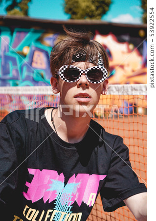Portrait of a young man with sunglasses against graffiti background outdoors Portrait of a young man with sunglasses against graffiti background outdoors 53922554
