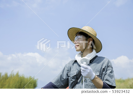 Male hand using a mini fan at field work 53923432
