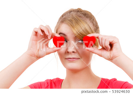 Funny woman holds red hearts over eyes 53924630