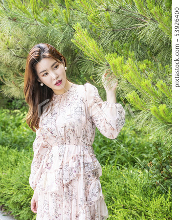 A young female model looking out of the woods 53926400