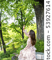Young female model looking up holding hands under the forest trees in Namsan Park, Seoul 53927614