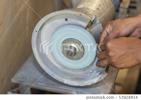 The worker use hand regrinding . 53928914