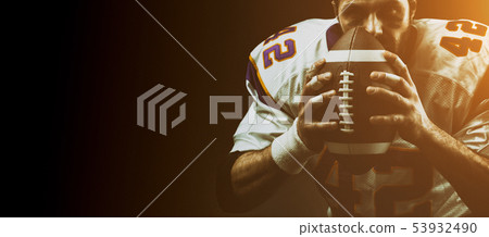 Portrait close-up, American football player, bearded without a helmet with the ball in his hands 53932490