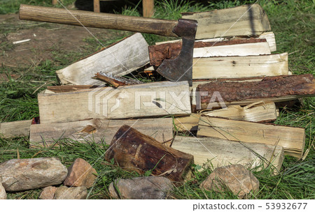 Cut firewood and old axe on green grass. Environmental concept 53932677