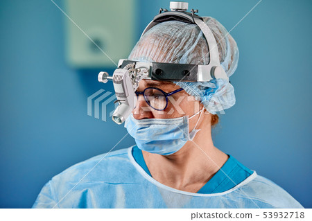 Close up portrait of female surgeon doctor wearing protective mask and hat during the operation 53932718