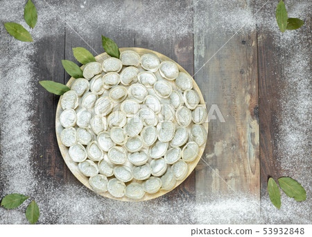 Meat dumplings - russian pelmeni on wooden background Meat dumplings - russian pelmeni on wooden background 53932848