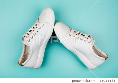 White trendy sneakers on turquoise background. 53933414