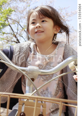 Toddler (4-year-old) riding a bicycle under the cherry blossoms Toddler (4-year-old) riding a bicycle under the cherry blossoms 53934064