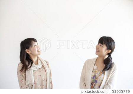 Two women looking up Two women looking up 53935779