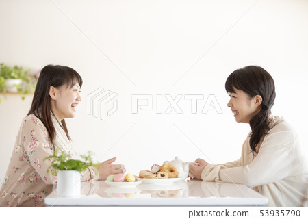 Two women enjoying tea time Two women enjoying tea time 53935790