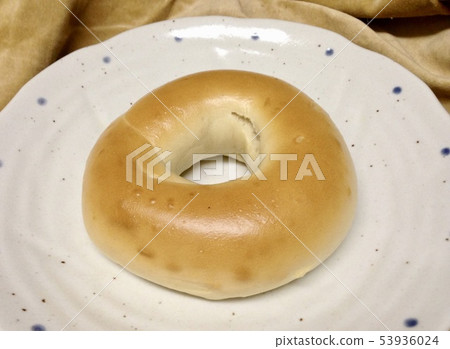 A piece of bagel bread on a white plate 53936024