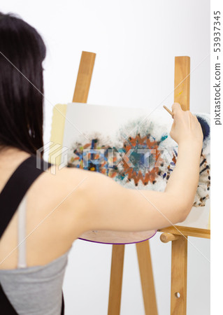 Artist painting on an easel Artist painting on an easel 53937345