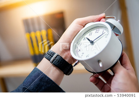 Male hand adjusting the time on white clock Male hand adjusting the time on white clock 53940091