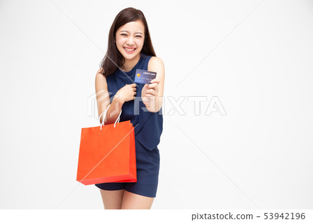 Happy young woman holding shopping bag and card Happy young woman holding shopping bag and card 53942196