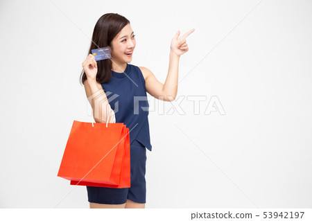 Happy young woman holding shopping bag and point Happy young woman holding shopping bag and point 53942197