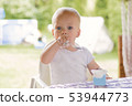 Portrait of a baby eating with a stained face. 53944773