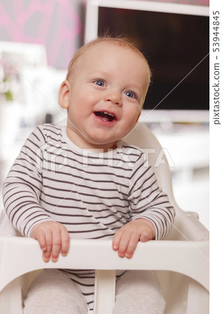 Happy smiling cute toddlersitting in the baby chair. Concept of happiness Happy smiling cute toddlersitting in the baby chair. Concept of happiness 53944845