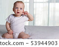 Playful little boy on the bed against window background 53944903