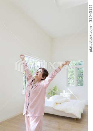 舒展用兩隻手的睡衣的資深婦女 53945135