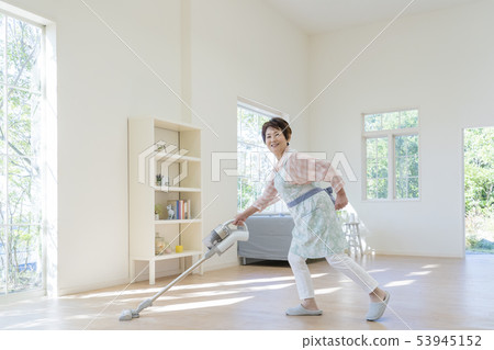 Senior woman posing holding a vacuum cleaner 53945152