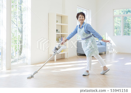 Senior woman posing holding a vacuum cleaner 53945158