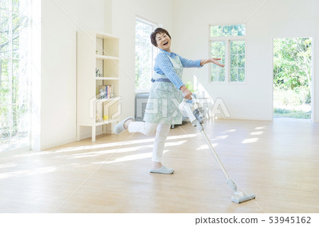 Senior woman posing holding a vacuum cleaner Senior woman posing holding a vacuum cleaner 53945162